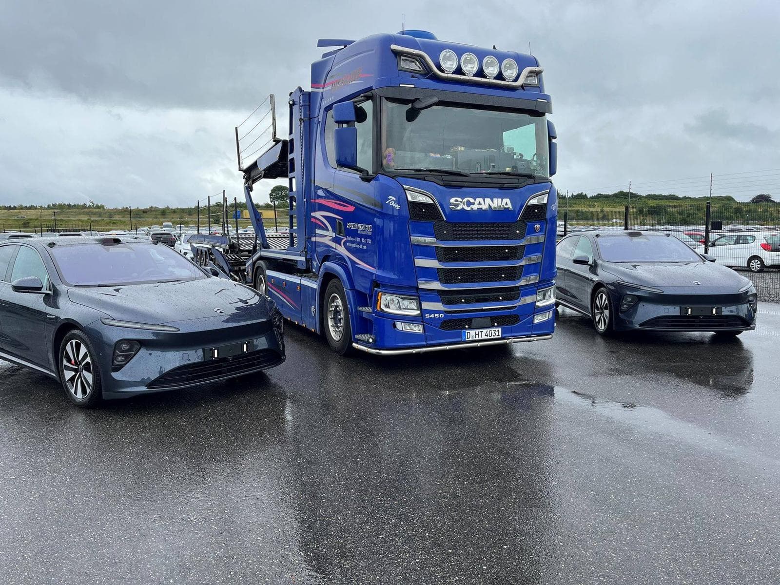 Fahrzeuge neben einem Autotransporter von Spedition HTL vor der Aufbereitung