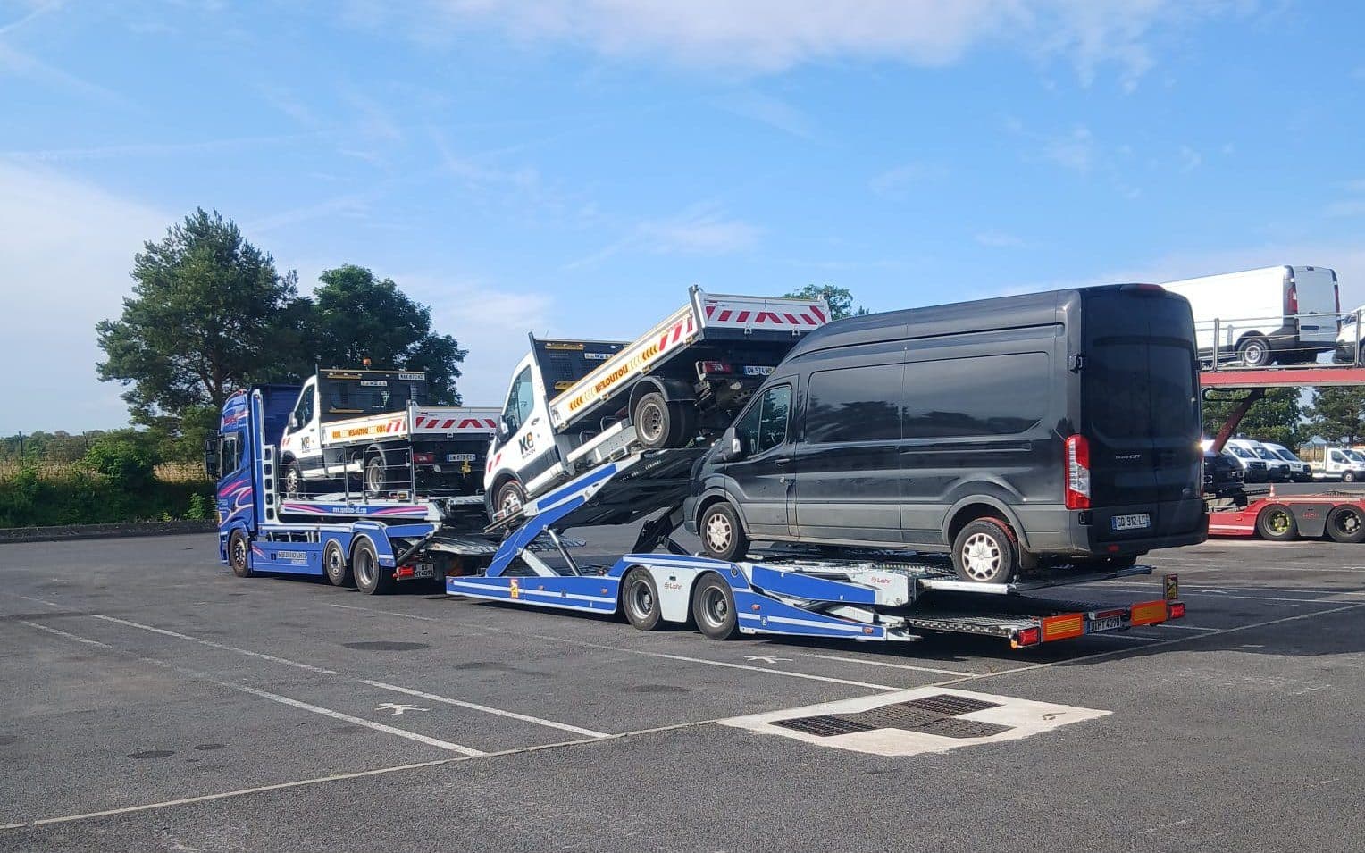 Autotransporter von Spedition HTL mit Transportern und Kippern beladen — Nutzfahrzeugtransport
